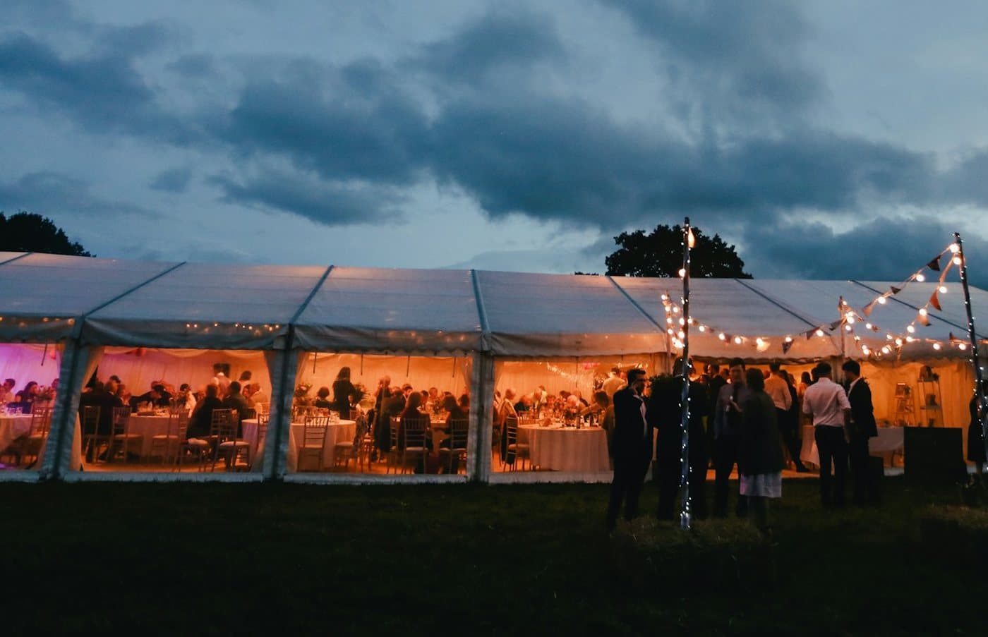 Opplyst partytelt med gjester om kvelden
